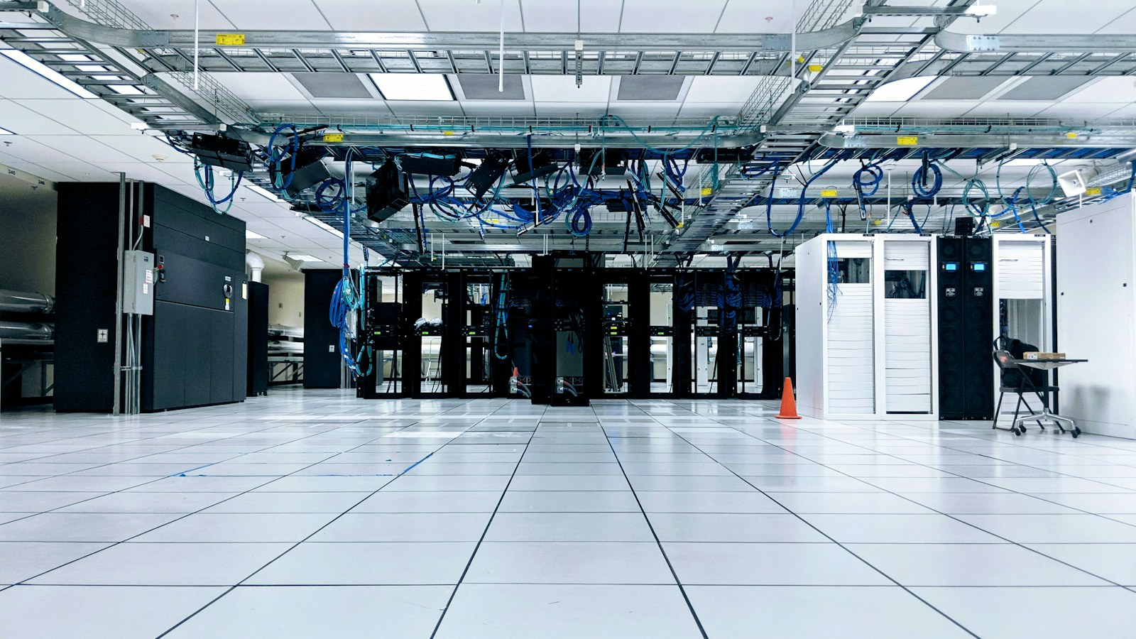 A data centre with server cabinets and overhead cables